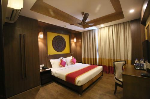 Cette chambre comprend un lit, un bureau et une chaise. dans l'établissement Vivin Luxury Suites, à Trivandrum