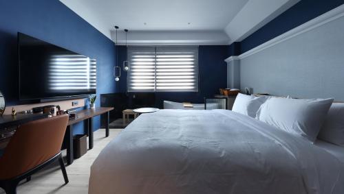 a bedroom with a large white bed and blue walls at 墾丁耳東華苑ErDong Manor in Kenting
