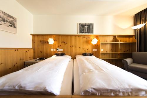 two beds in a room with wood paneling at Spenglers Inn in Davos