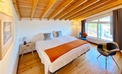 sypialnia z łóżkiem i dużym oknem w obiekcie Miradouro da Papalva Guest House - Pico - Azores w mieście São João