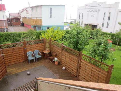 a wooden deck with two chairs and a table at Teigur Guesthouse in Akranes
