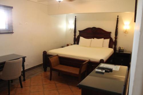 a hotel room with a bed and a table and chairs at Altamont West Hotel in Montego Bay
