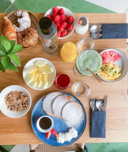 a wooden table with plates of breakfast food on it at Concepcio by Nobis, Palma, a Member of Design Hotels in Palma de Mallorca