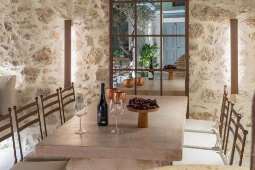 a dining room with a table with two wine glasses at Inotropes Boutique Suites - Adults Only in Archanes