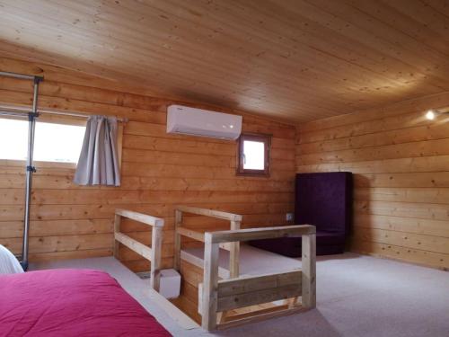 Blockhütte mit einem Bett und einem TV in der Unterkunft Le Petit Chalet de Nîmes Shantay Youstay in Nîmes