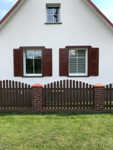 a fence in front of a house with windows at Agroturystyka "Zielone Zacisze" in Łagów