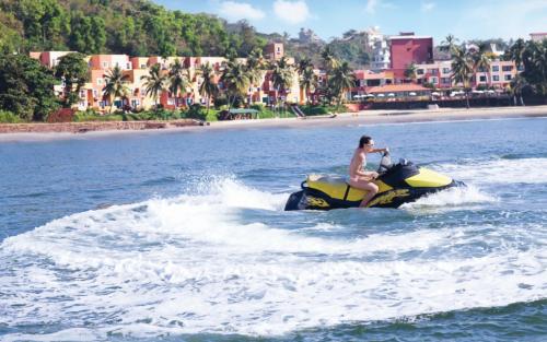 a woman riding a jet ski in the water at Taj Cidade de Goa Horizon, Goa in Panaji