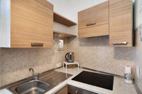 a kitchen with wooden cabinets and a sink at Casa via Montà in centro in Sanremo