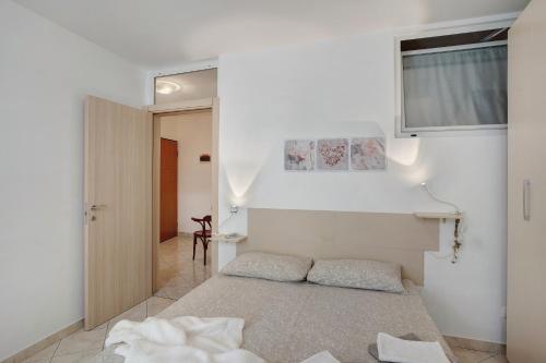 a white room with a bed and a window at Casa via Montà in centro in Sanremo