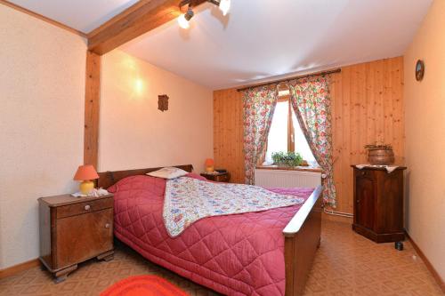 1 dormitorio con 1 cama con edredón rojo en Gites ou Chambres d'hôtes à la ferme, en Orbey