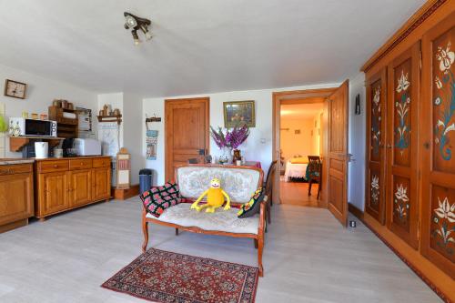 un salon avec une chaise et une cuisine dans l'établissement Gites ou Chambres d'hôtes à la ferme, à Orbey