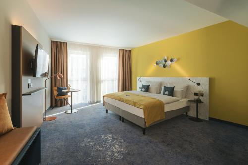 ein Hotelzimmer mit einem Bett und einem TV in der Unterkunft the niu Kettle in Stuttgart