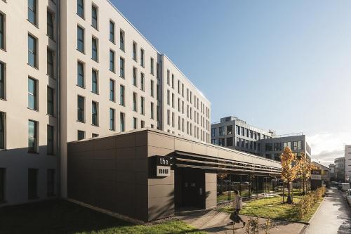 a person walking in front of a building at Holiday Inn - the niu, Kettle Stuttgart Vaihingen by IHG in Stuttgart