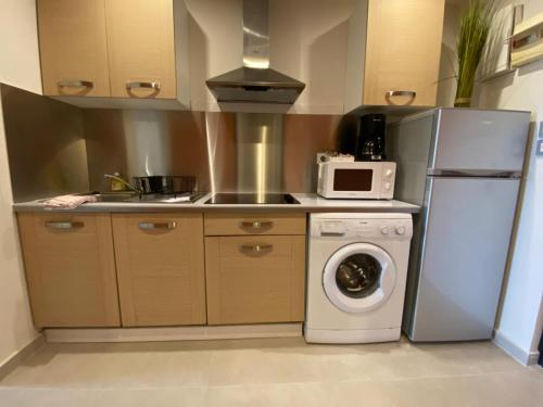 a kitchen with a refrigerator and a washing machine at Ocean SXM Studio in Cul de Sac