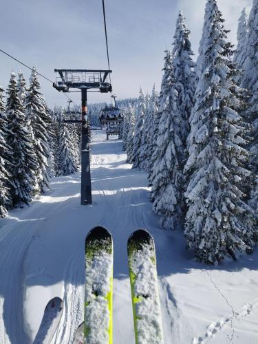 a pair of skis in the snow next to a ski lift at Planinski vrhovi Jelač in Kopaonik