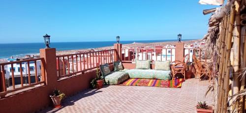 a balcony with a couch and the ocean in the background at Brothers House 1 in Imsouane
