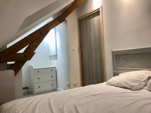 Un dormitorio con una cama blanca y una ventana. en Appartement chaleureux et lumineux avec vue ! au centre Alsace, en Sélestat