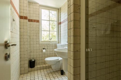a bathroom with a toilet and a sink and a window at Mädesüß 02 in Ahrenshoop