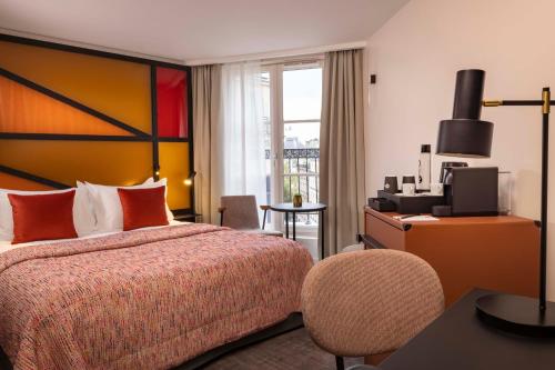 a hotel room with a bed and a television at Le 12 Hôtel in Paris