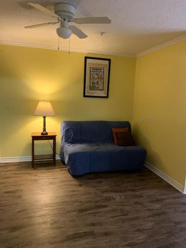 a living room with a blue couch and a table at Lakelawn B&B and Motel in Yarmouth