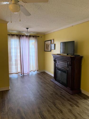 an empty living room with a television and a fireplace at Lakelawn B&B and Motel in Yarmouth