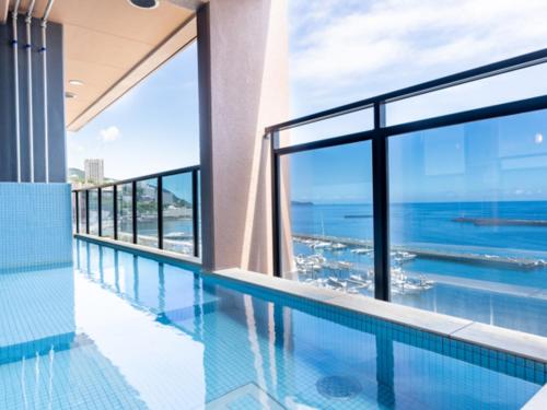 a swimming pool with a view of the ocean at LiVEMAX RESORT Atami OCEAN in Atami