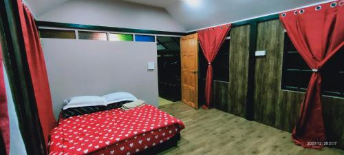 a bedroom with a red and white bed with curtains at Bungalow Mat Hj Limah in Alor Setar