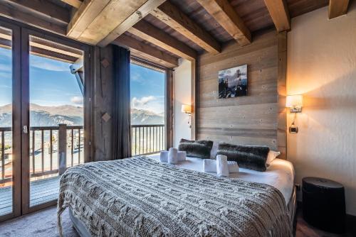 a bedroom with a large bed and a large window at Apartment Tiama Courchevel 1850 - by EMERALD STAY in Courchevel