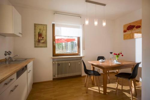 uma cozinha com mesa e cadeiras e uma janela em Ferienwohnung Strohmeyer em Oberaudorf
