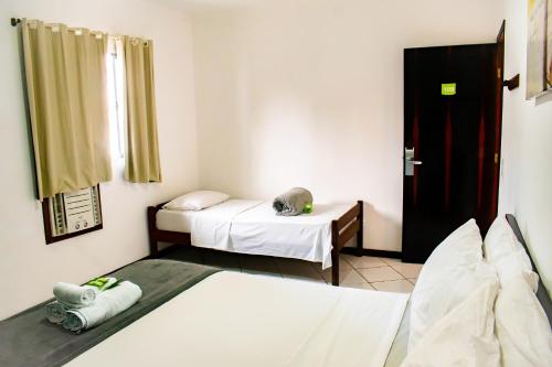a room with two beds and a door to a bedroom at Che Lagarto Paraty in Paraty