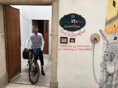 a man riding a bike in front of a sign at La Vista in Calitri