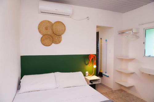 sypialnia z białym łóżkiem i zielonym zagłówkiem w obiekcie CASA PITANGA w mieście Fernando de Noronha