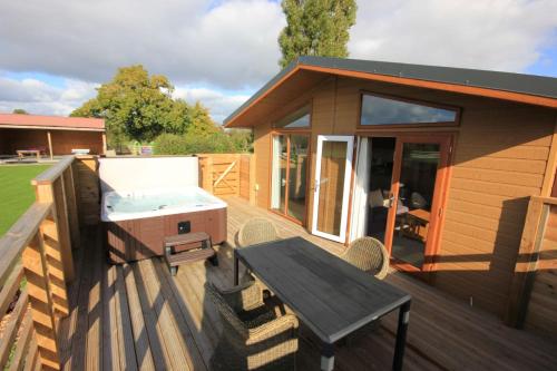 a small house with a hot tub on a deck at Barker Stakes Farm in Pickering