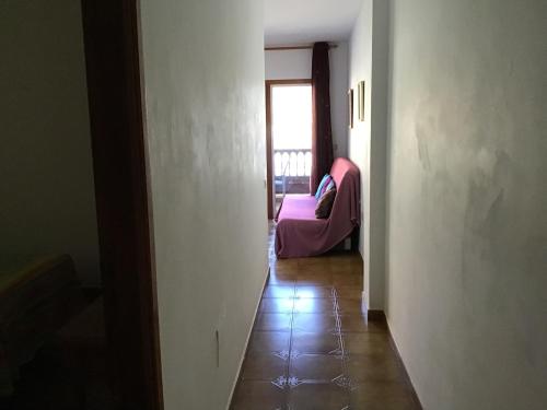 a hallway with a room with a couch and a window at Apartamentos Playamar in La Playa Calera