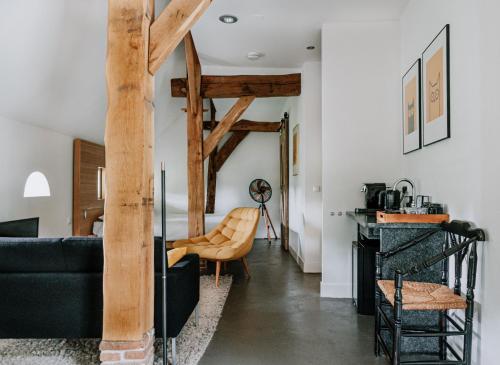 a living room with a black couch and wooden beams at De Vijf Suites in Elp