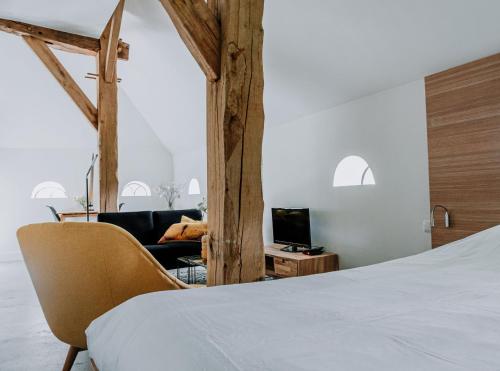 a bedroom with a bed and a couch and a television at De Vijf Suites in Elp