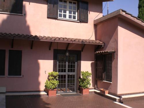 a pink building with two potted plants in front of it at Villa di Christian e Michelle in Rome