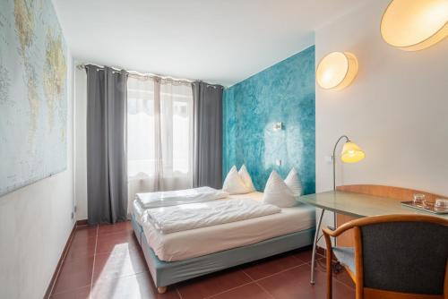 a hotel room with a bed and a desk at Hotel Schottenhof in Mainz