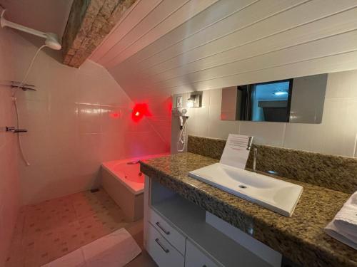 盧米亞爾的住宿－Chalé do Recanto，浴室配有盥洗盆和红色浴缸。
