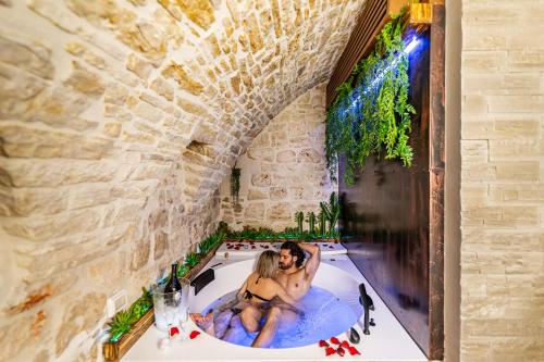 a couple sitting in a bathtub in a castle bathroom at Il Piccolo Borgo - Suite in Santeramo in Colle