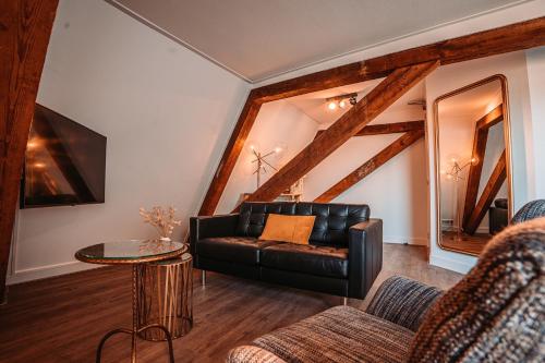 a living room with a leather couch and a table at Short Stay Apartments Heerenveen in Heerenveen