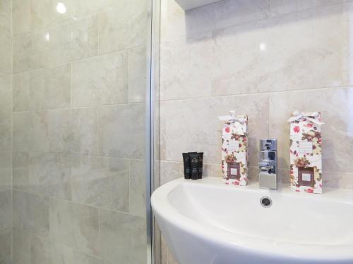 a bathroom with a white tub and a shower at Tudors eSuites 4 Bedroom House with Garden & 9 Beds in Coventry