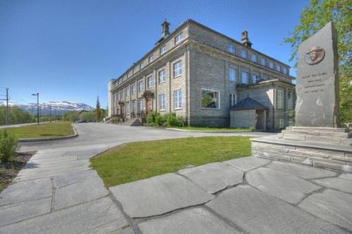 a large brick building with a monument in front of it at Oppdal Turisthotell in Oppdal
