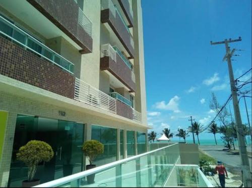 a building with a person walking in front of it at FLAt COMPLETO BEIRA MAR in Cabedelo