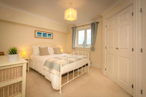 a bedroom with a bed and a window at Seaviews Sovereign Harbour - adults-only apartment in Eastbourne