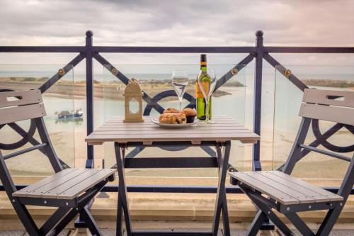 a table with two chairs and a glass of wine at Seaviews Sovereign Harbour - adults-only apartment in Eastbourne