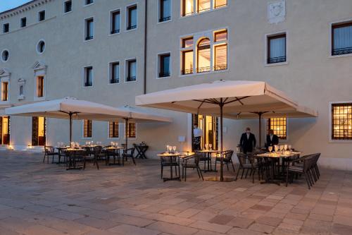 a group of tables and umbrellas in front of a building at Ca'di Dio-Small Luxury Hotel in Venice
