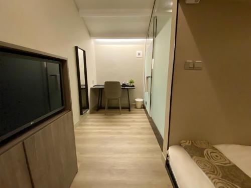 a hallway with a tv and a table in a room at ST Signature Jalan Besar, SHORT OVERNIGHT, 8 Hours, 1159PM-8AM in Singapore