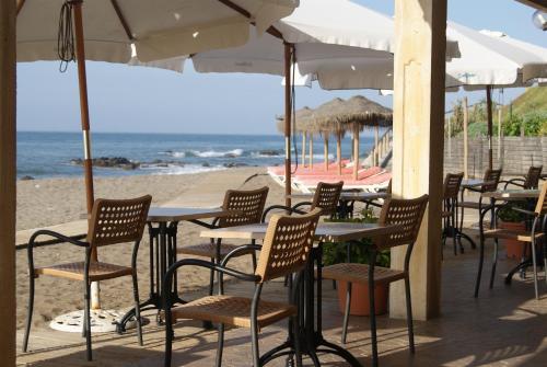 eine Gruppe von Tischen und Stühlen am Strand in der Unterkunft Apartamentos La Dorada in La Cala de Mijas