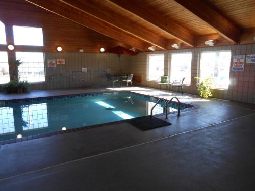 a large swimming pool in a large room with windows at AmericInn by Wyndham McAlester in McAlester